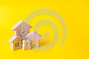 Three houses on a yellow background. Buying and selling of real estate, construction. Apartments and apartments. City, settlement.