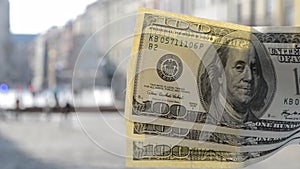 Three hundred dollar bills on blurred background of european old ancient street