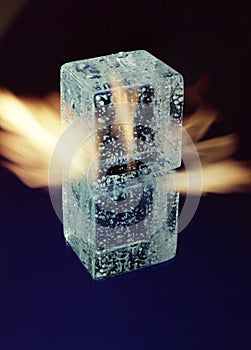 three ice cubes against the background of fire, fire and ice, place under the text