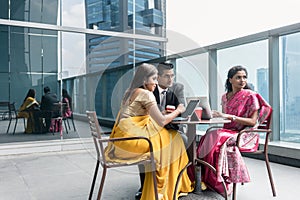 Three Indian business people talking during break at work