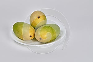 Three Indian Dasheri mangoes on white