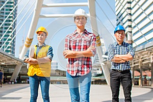 Three Industrial engineer wear safety helmet engineering standing with arms crossed