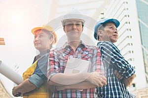 Three Industrial engineer wear safety helmet engineering standing with arms crossed on building outside