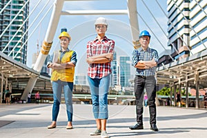 Three Industrial engineer wear safety helmet engineering standing with arms crossed holding inspection tablet and smile