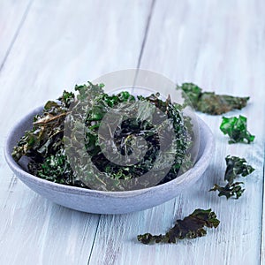 Three ingredient baked green kale chips with sea salt and olive oil, in gray bowl, square format