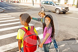Three international kids ready to cross road