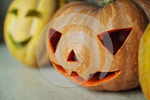 Three jack-o`-lanterns from pumpkin and melons on kitchen table.