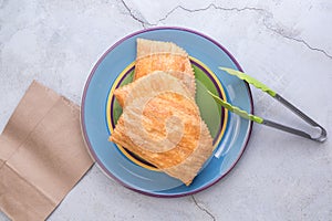 Three Jamaican beef patties on a large colourful plate photo