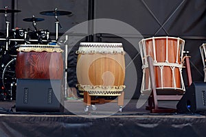 Three Japanese Taiko Nagado and Okedo drums standing in a row on stage