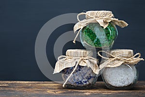 Three jars with different sea salt on a dark background