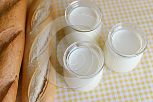 Three jars with Greek yoghurt and a crispy French baguette