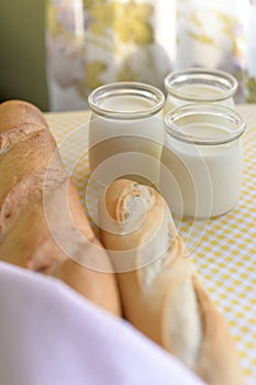 Three jars with Greek yoghurt and a crispy French baguette