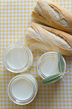 Three jars with Greek yoghurt and a crispy French baguette