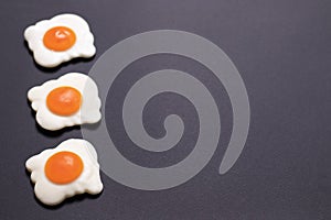 Three jelly-fried eggs lie to the left on a black background