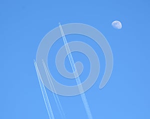 Three jet two-turbine aircraft in flight on blue sky background and moon