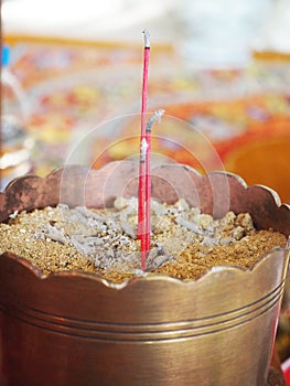 Three joss sticks in golden censor.