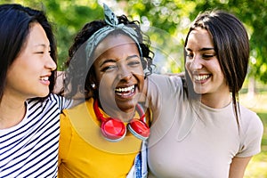 Three joyful multiracial young teenage girls having fun together outdoors