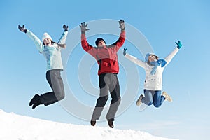 Three jumping young people in winter