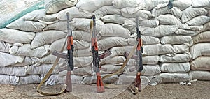 Three Kalashnikovs standing near sandbagged fortifications. AK-74 outdoor