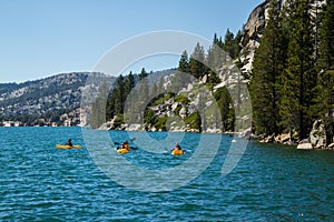 Three kayakers on Echo Lake in Sierra Nevada mountains, California, USA