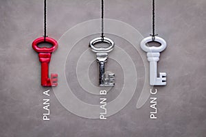 Three keys red silver and white on grey background