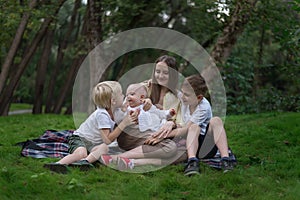 Three kids and amom in a park in clearing. Older siblings for my youngest sister