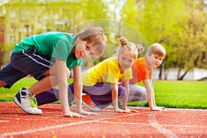 Three kids close-up in uniforms ready to run