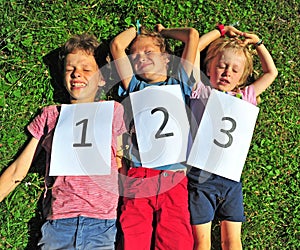 Three kids luying on grass