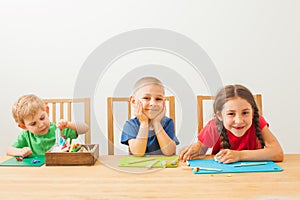Three kids play with colorful play dough