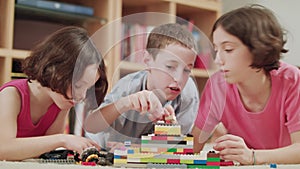 Three kids playing with lego bricks at home