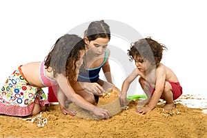 Three kids playing in the sand