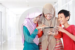 Three kids playing tablet computer