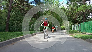 Three kids riding bicycles in spring day.