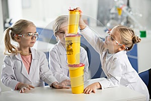 Three kids in science laboratory wearing lab coats