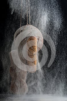 Three kinds of fresh bread in a floury fog on a black background