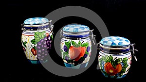 Three Kitchen Canisters Against Black Background