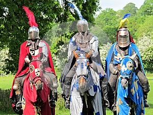 Three knights in shining armor on horseback