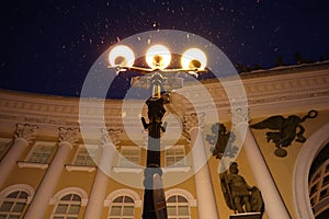 Three lanterns shine brightly in night Petersburg