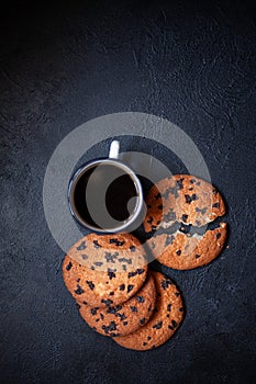 Three large cookies on a black concrete background.