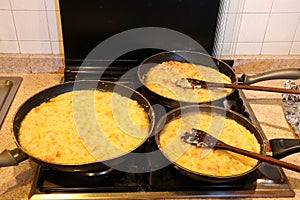 Three large pots with the typical dish called FRICO of Italy