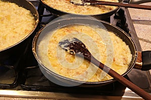 Three large pots with the typical italian dish called FRICO