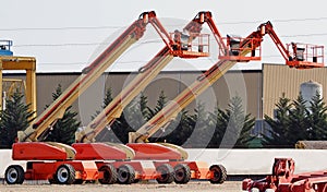 Three large work aerial platform lined up in an industrial site