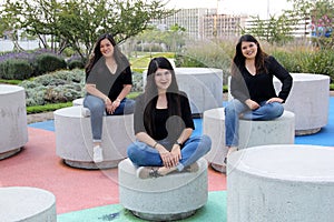 Three latin adult sisters as a loving family happily dressed in black outdoors in a park in harmony, freedom and happiness