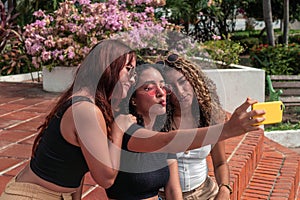 Three Latin Friends Making Selfie On Park
