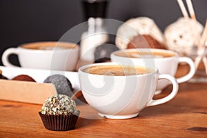 Three latte cups and small cakes on the wooden table in the cafe. Communication over a Cup of coffee, Coffee break