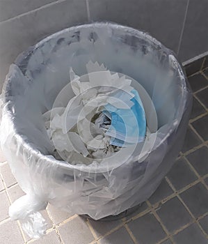 Three-layer surgical mask in a garbage tank