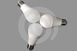 Three led bulb light and energy-saving lamp on table on gray background