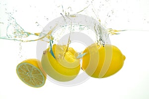 Three lemons spash in water on white background photo