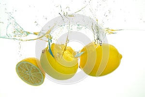 Three lemons spash in water on white background