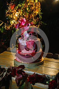 Three-level cake decorated with zantedeschian flower, red leaves and red `falling off` icing photo